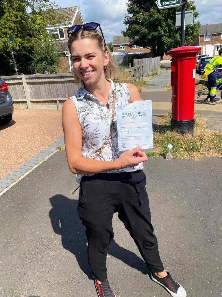 Learner holding her driving test pass certificate