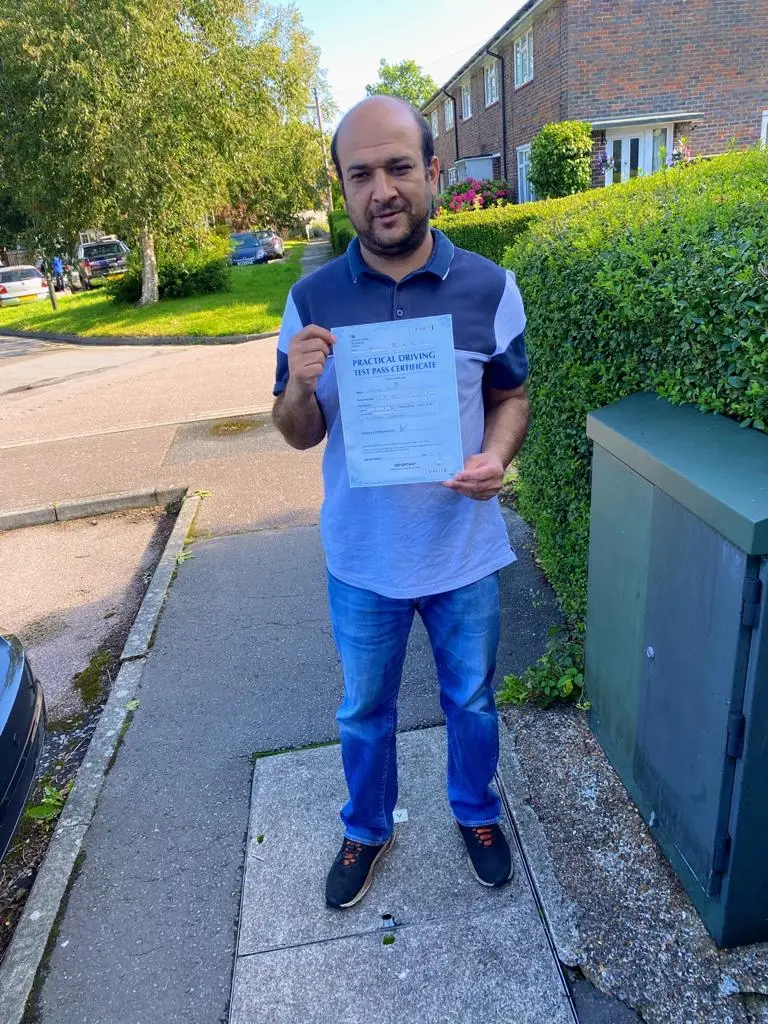 Learner holding his driving test pass certificate